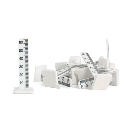 Vita plastpinnar med tryckta millimeterskaloror och kvadratiska baser. En står upprätt, resten är staplade.